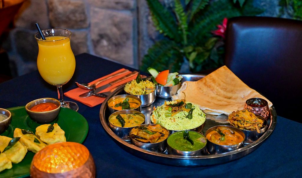 A Kerala thali with a dosa and an orange juice, served at Herb Restaurant